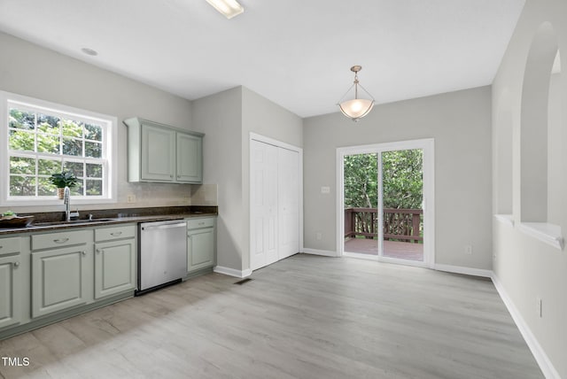 8820 Waynick Dr, Raleigh, NC 27617 - kitchen featuring stainless steel dishwasher, a sink, dark countertops, and light wood-style floors