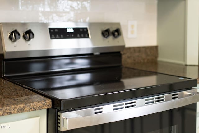 8820 Waynick Dr, Raleigh, NC 27617 - kitchen view of stainless steel electric stove, dark countertops, and tasteful backsplash
