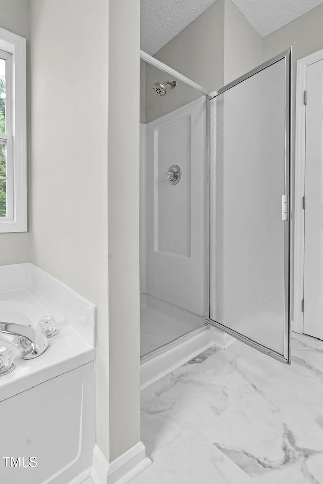 8820 Waynick Dr, Raleigh, NC 27617 - bathroom featuring a shower stall, a textured ceiling, marble look tile flooring, and a garden tub