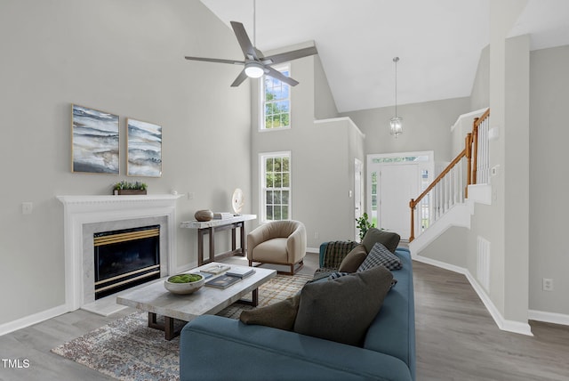 8820 Waynick Dr, Raleigh, NC 27617 - living area with high vaulted ceiling, wood finished floors, stairs, baseboards, and ceiling fan