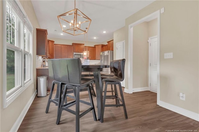 dining area featuring a chandelier, baseboards, healthy amount of natural light, recessed lighting, and wood finished floors