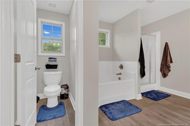 full bathroom featuring wood finished floors, toilet, a bath, and baseboards