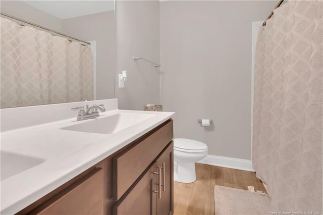 full bath featuring wood finished floors, toilet, double vanity, baseboards, and a shower with shower curtain