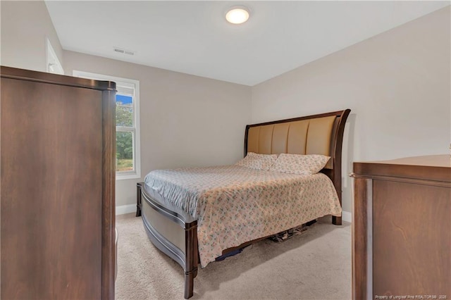 bedroom featuring light colored carpet and baseboards