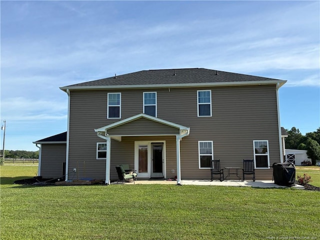 back of property with a yard and a patio