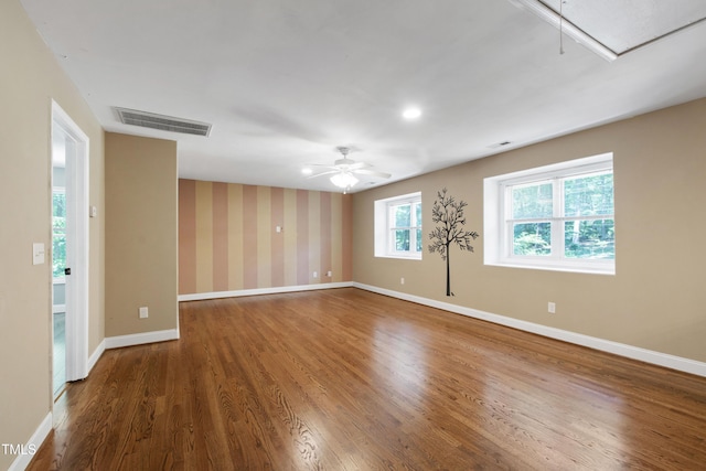 1005 Temple St, Raleigh, NC 27609 - spare room with attic access, wood finished floors, ceiling fan, baseboards, and wallpapered walls