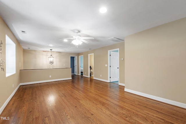 1005 Temple St, Raleigh, NC 27609 - spare room with baseboards, wood finished floors, ceiling fan, and a chandelier