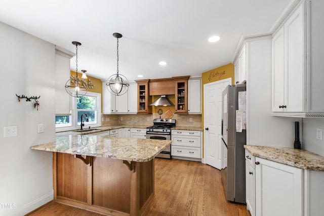 1005 Temple St, Raleigh, NC 27609 - kitchen with stainless steel appliances, a peninsula, a sink, glass insert cabinets, and wall chimney range hood