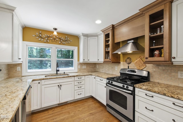 1005 Temple St, Raleigh, NC 27609 - kitchen with stainless steel range with gas cooktop, wall chimney range hood, a sink, decorative backsplash, and light stone counters