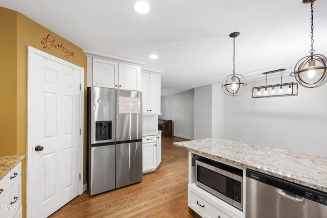 1005 Temple St, Raleigh, NC 27609 - kitchen featuring appliances with stainless steel finishes, light wood finished floors, white cabinetry, recessed lighting, and light stone countertops