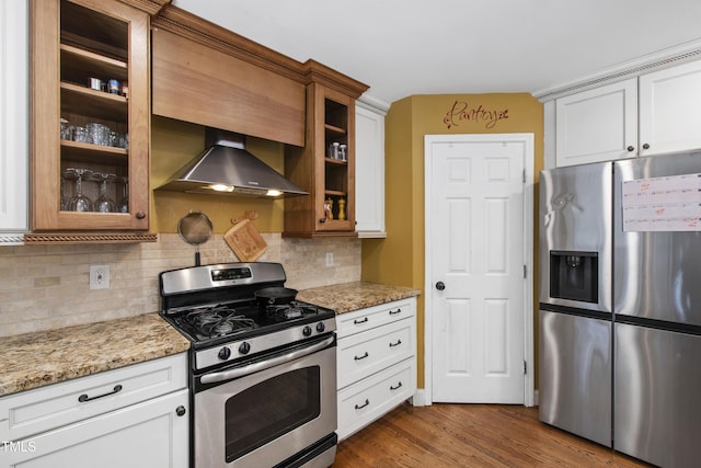 1005 Temple St, Raleigh, NC 27609 - kitchen with stainless steel appliances, wall chimney range hood, tasteful backsplash, and glass insert cabinets