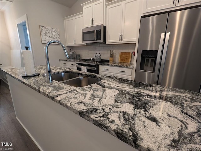 3904 Lundin Dr, Greensboro, NC 27407 - kitchen with appliances with stainless steel finishes, a sink, white cabinetry, backsplash, and dark wood-type flooring