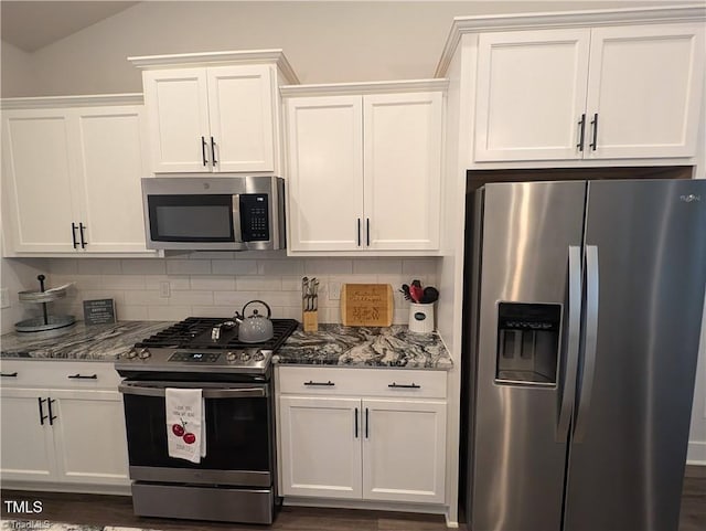 3904 Lundin Dr, Greensboro, NC 27407 - kitchen with appliances with stainless steel finishes, white cabinets, decorative backsplash, stone counters, and lofted ceiling