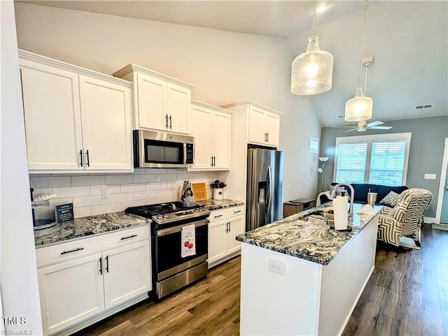 3904 Lundin Dr, Greensboro, NC 27407 - kitchen with stainless steel appliances, lofted ceiling, tasteful backsplash, dark wood-style flooring, and white cabinetry