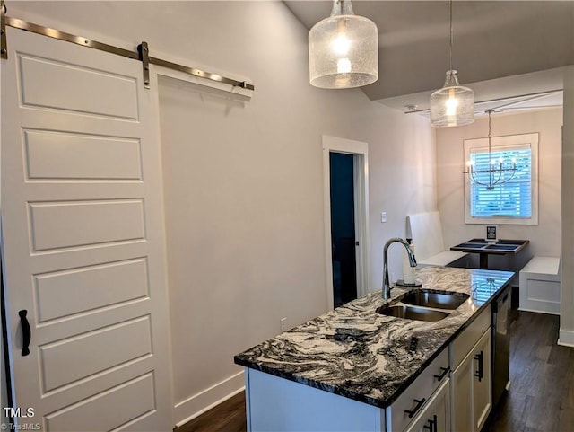 3904 Lundin Dr, Greensboro, NC 27407 - kitchen with a sink, dark stone countertops, dark wood-type flooring, a barn door, and a center island with sink