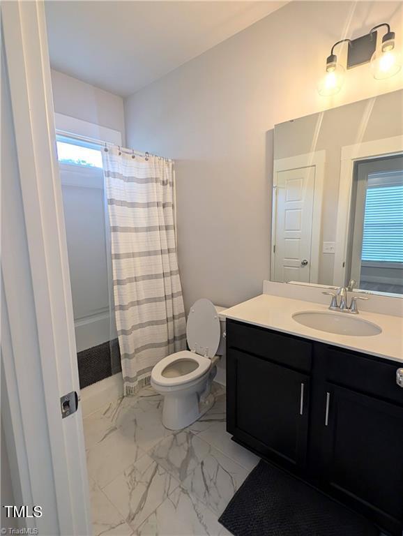 3904 Lundin Dr, Greensboro, NC 27407 - bathroom featuring toilet, vanity, healthy amount of natural light, and marble look tiles