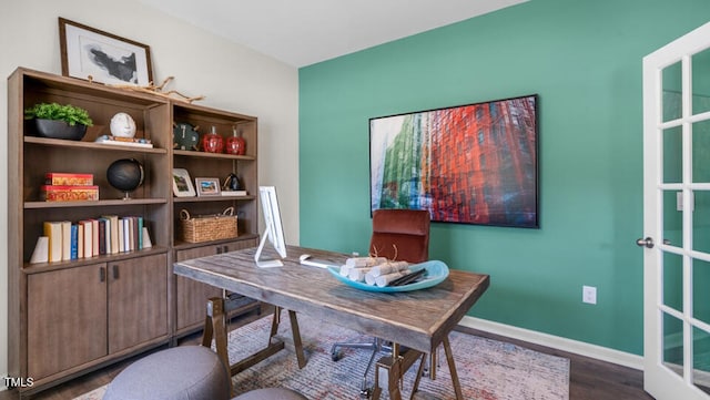 home office with dark wood-style flooring and baseboards