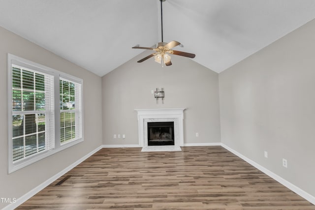 unfurnished living room featuring a ceiling fan, wood finished floors, a high end fireplace, baseboards, and lofted ceiling