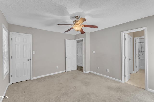 unfurnished bedroom with light carpet, a textured ceiling, baseboards, and ceiling fan