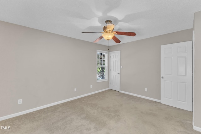 empty room with a ceiling fan, baseboards, and light colored carpet