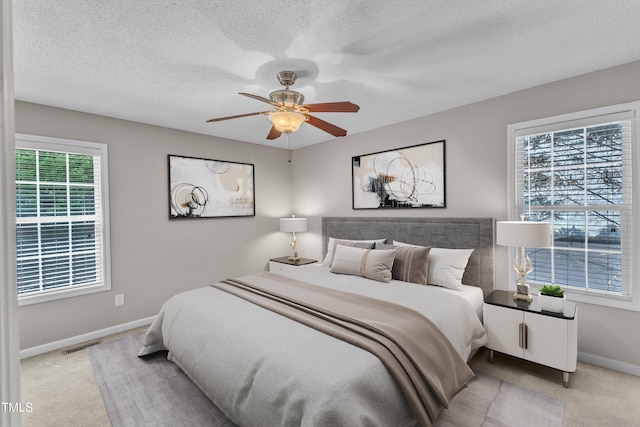bedroom featuring carpet floors, baseboards, a textured ceiling, and ceiling fan