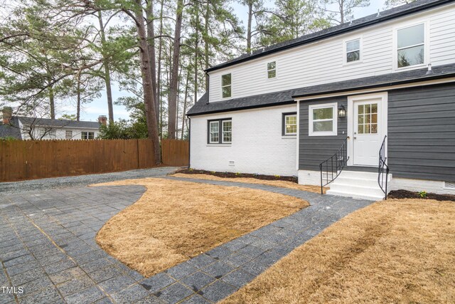 2515 W Club Blvd, Durham, NC 27705 - rear view of property featuring entry steps, crawl space, a patio area, roof with shingles, and brick siding