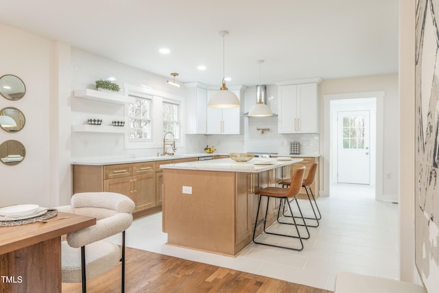 2515 W Club Blvd, Durham, NC 27705 - kitchen featuring wall chimney range hood, a kitchen bar, a sink, light countertops, and a center island