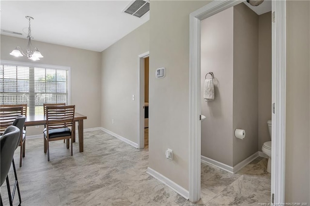 dining room featuring baseboards and a chandelier