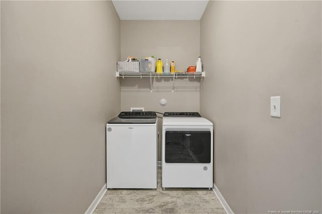 laundry room featuring separate washer and dryer and baseboards