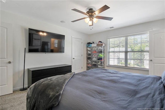 bedroom with a ceiling fan, baseboards, and light carpet
