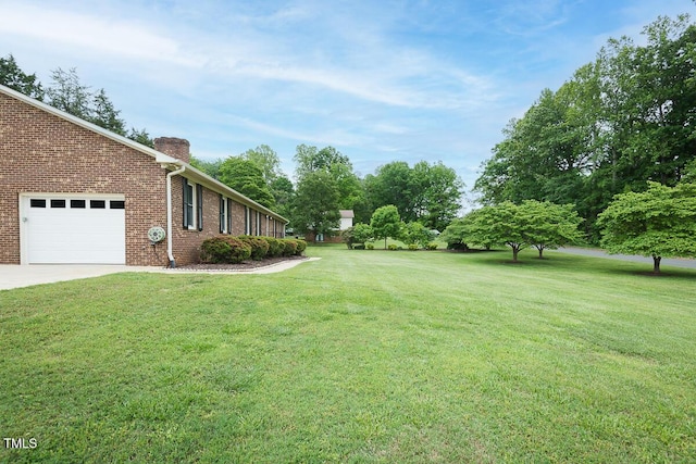 view of green lawn with a garage and concrete driveway