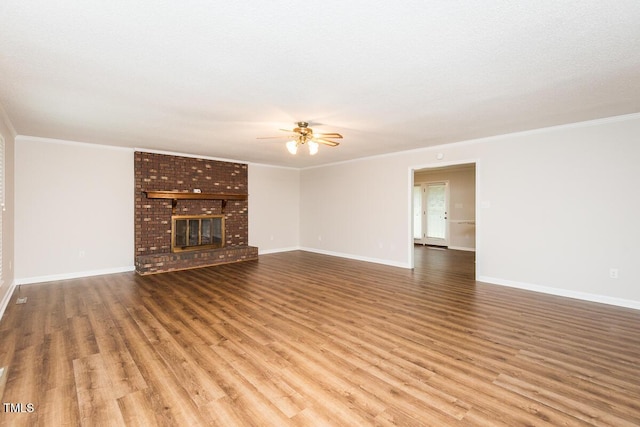 unfurnished living room with crown molding, ceiling fan, wood finished floors, and baseboards