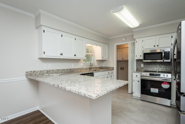 kitchen with stainless steel appliances, a sink, a peninsula, ornamental molding, and white cabinetry
