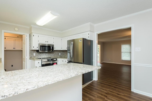 kitchen featuring appliances with stainless steel finishes, a peninsula, crown molding, dark wood-style floors, and tasteful backsplash