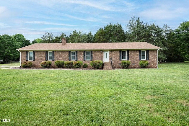 ranch-style house with brick siding, a front yard, and a chimney