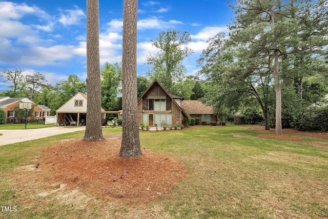 view of front of property with curved driveway and a front yard