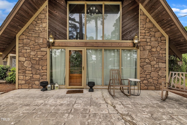 property entrance featuring stone siding and a patio area