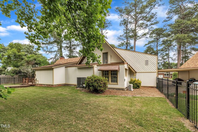 rear view of property featuring central AC unit and a chimney