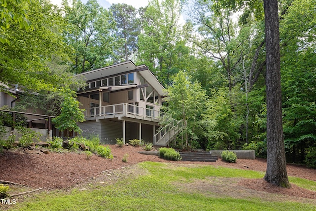 rear view of property featuring stairs and a wooden deck