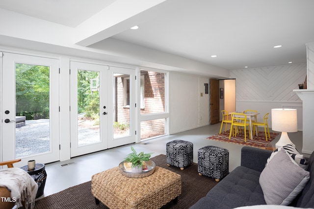 living area with french doors, recessed lighting, and finished concrete flooring
