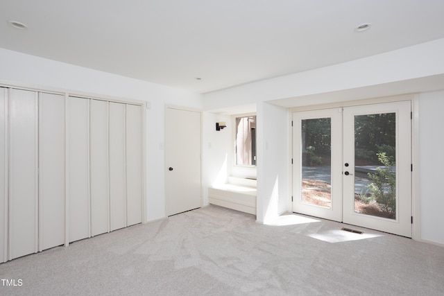 unfurnished bedroom with french doors, access to outside, carpet, and two closets