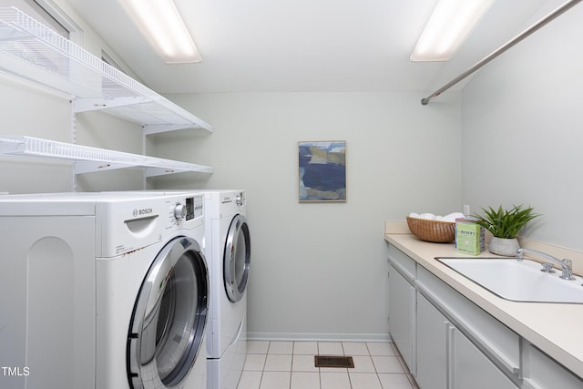 clothes washing area with washer and dryer, light tile patterned flooring, baseboards, and cabinet space