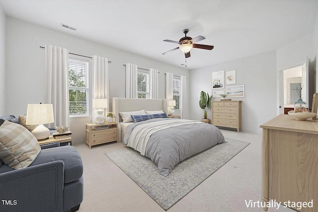 bedroom featuring light colored carpet and a ceiling fan