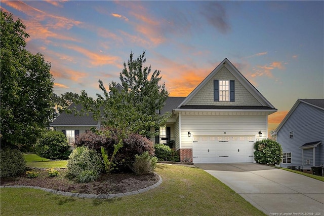 view of front of home with concrete driveway, a yard, a garage, and brick siding