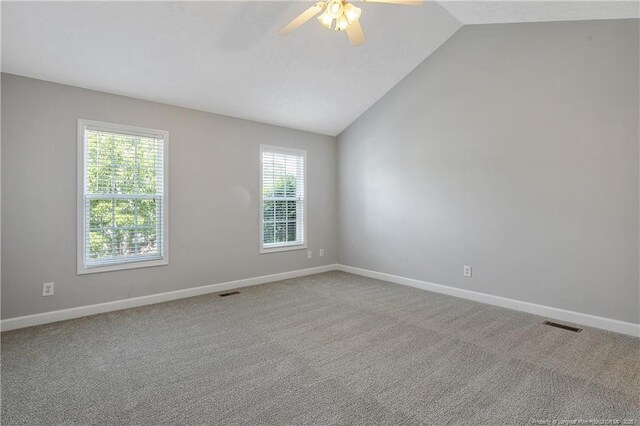empty room with lofted ceiling, a ceiling fan, baseboards, and carpet floors