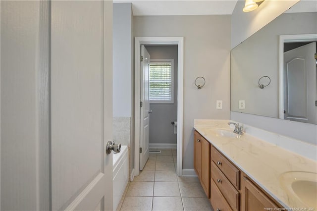 full bath with double vanity, tile patterned floors, baseboards, and a tub