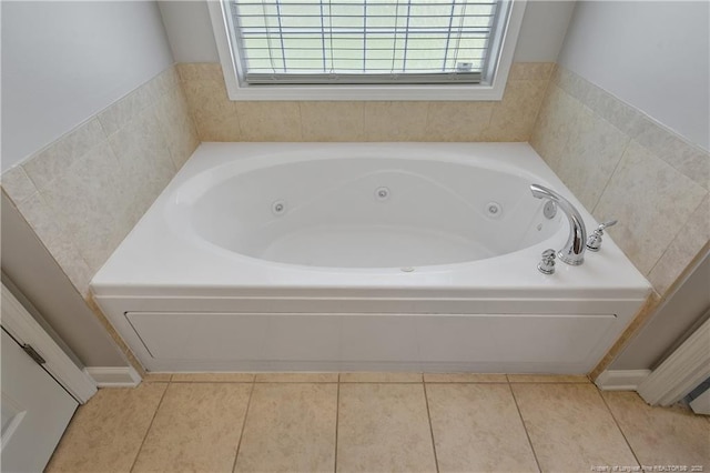 bathroom with a tub with jets and tile patterned floors