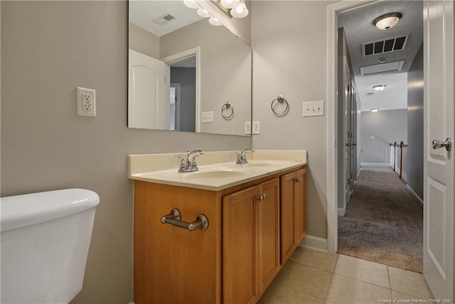 bathroom with double vanity, tile patterned flooring, toilet, and baseboards