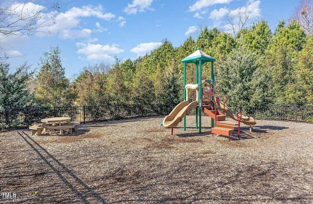 community playground with fence and a view of trees