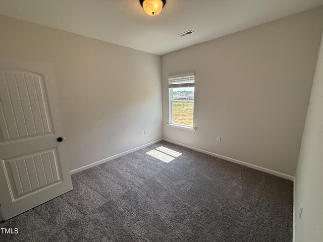 carpeted empty room featuring baseboards